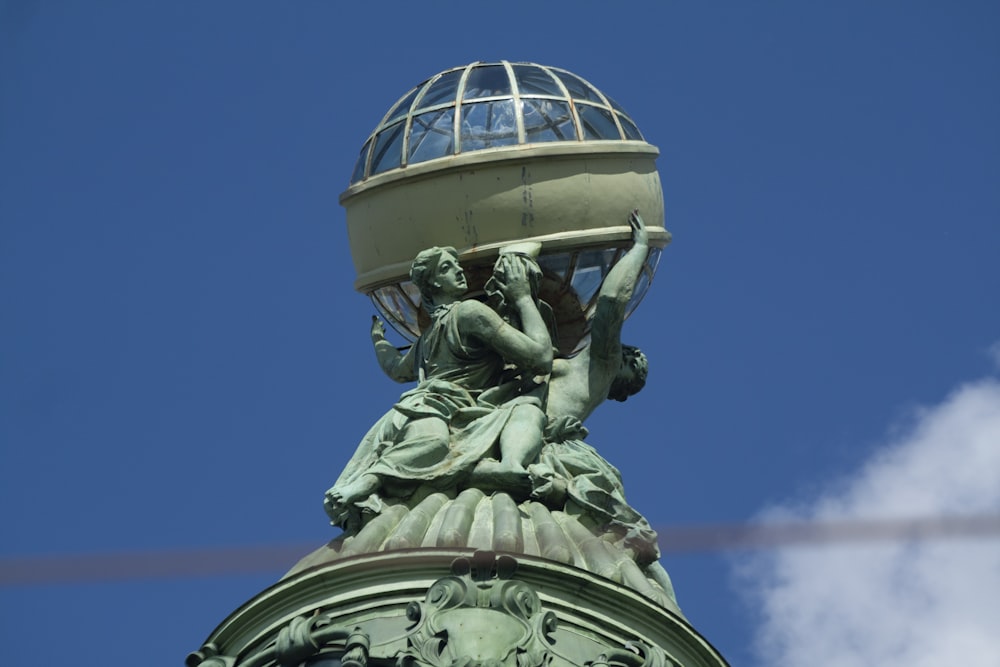 Una estatua en la parte superior de un edificio con un fondo de cielo