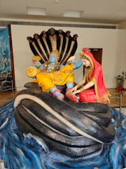 A detailed illustration of Lord Vishnu reclining on the cosmic serpent.