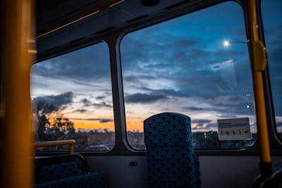 Geometric patterns subtly woven into a background of a golden-hued luxury bus at sunset.