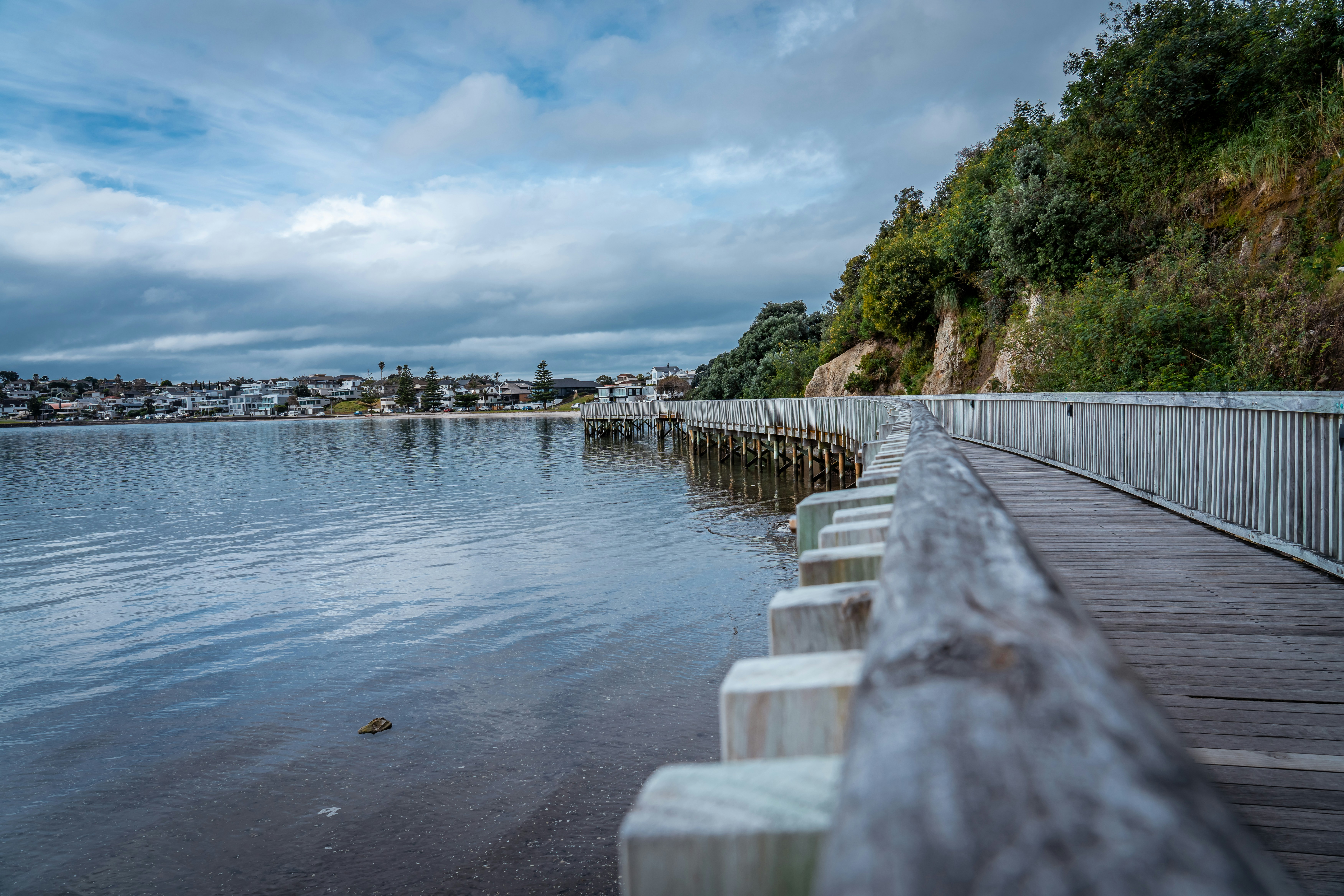 A long wooden pier next to a body of water photo – Free Water Image on ...