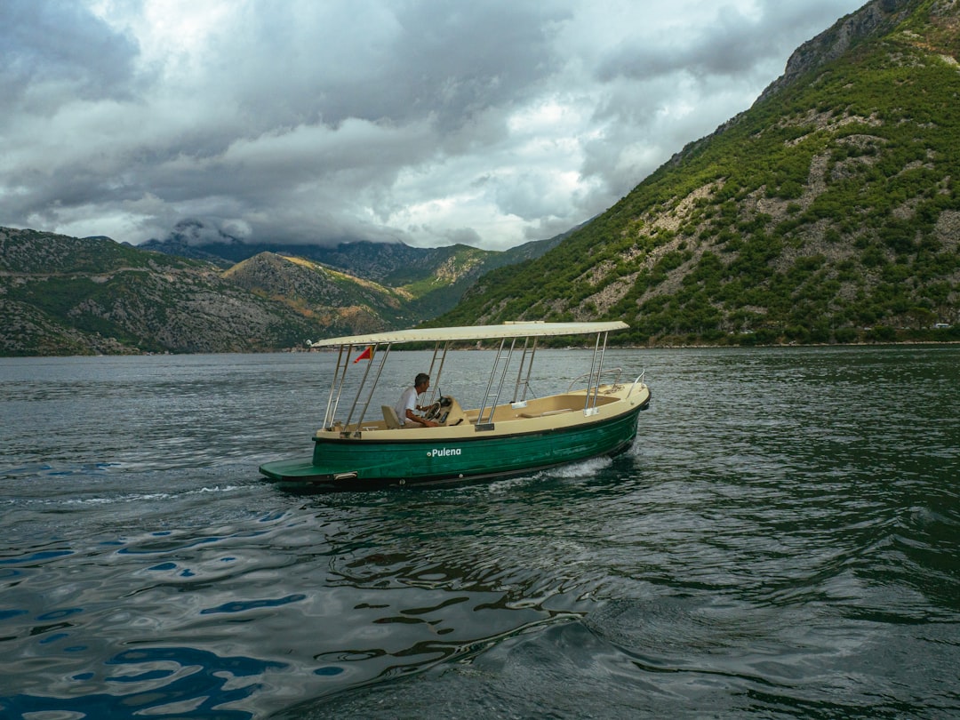 a small green boat on a large body of water,