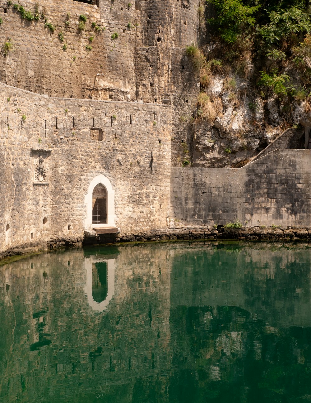 a body of water near a stone wall