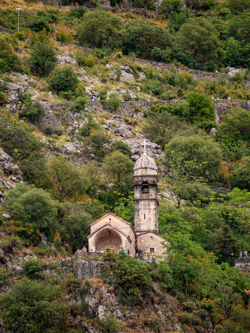 a very tall tower sitting on top of a lush green hillside