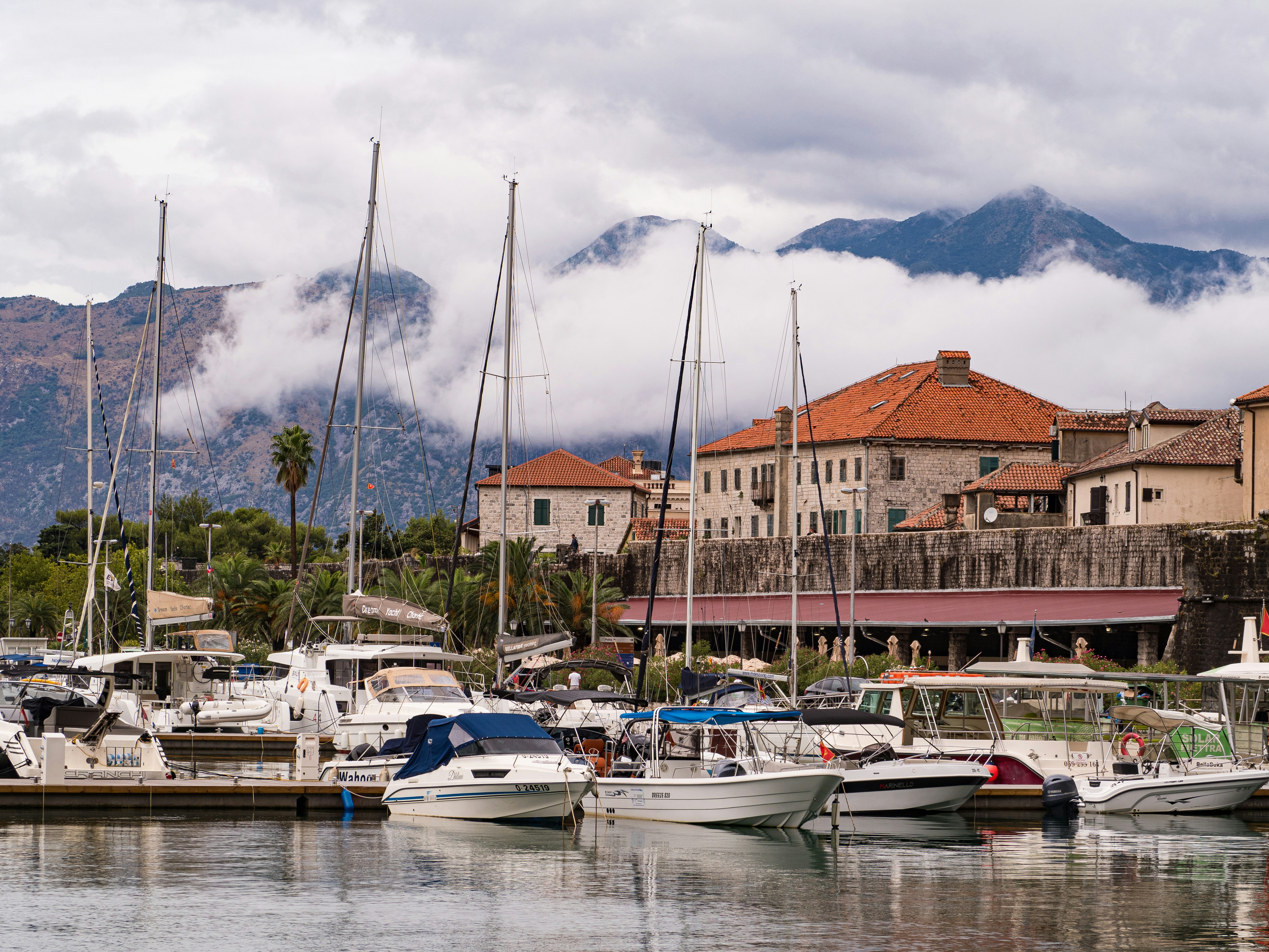 a harbor filled with lots of boats next to tall buildings