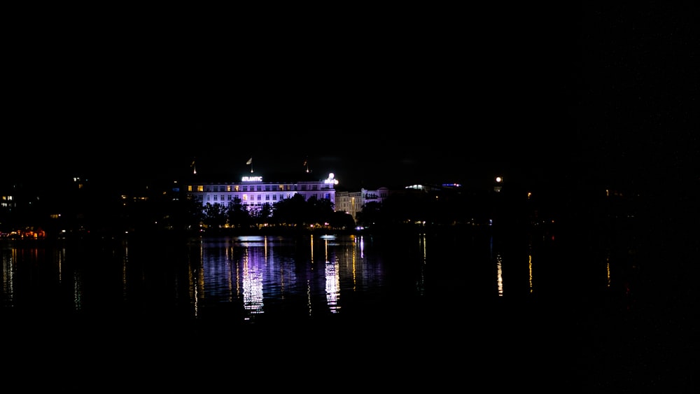 a large building sitting on top of a lake at night