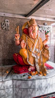 Golden statue of Ganesha with marigold garlands in a temple corner.