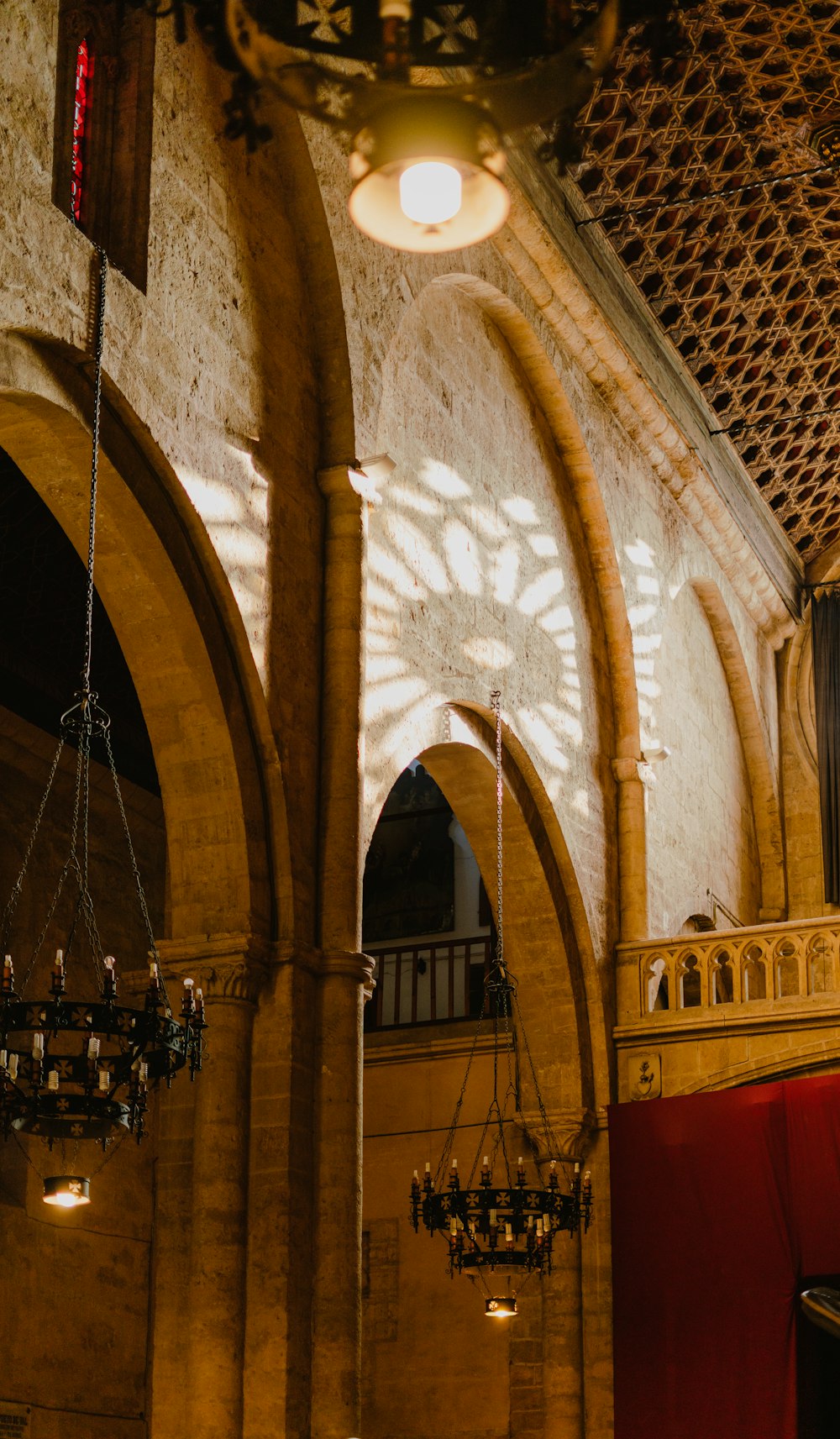 a large room with a chandelier and a red curtain