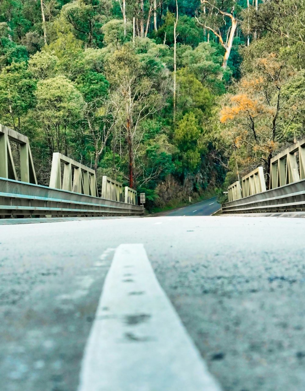 an empty road with a bridge in the background