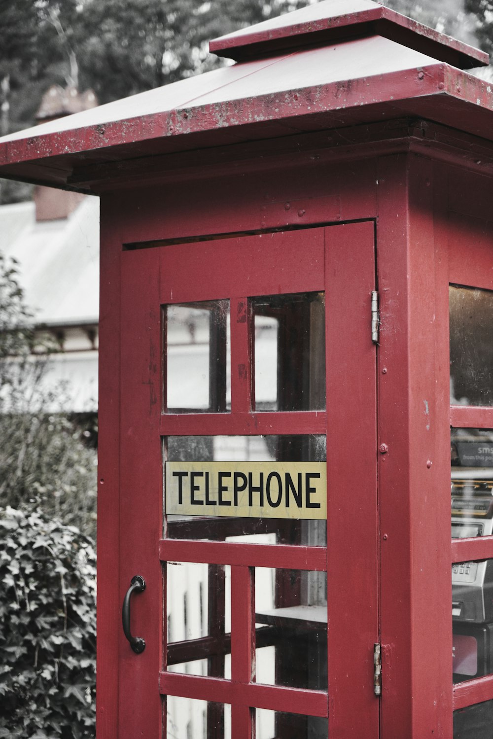 a red telephone booth with a sign on it