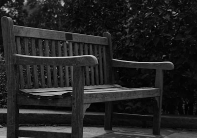 a black and white photo of a wooden bench