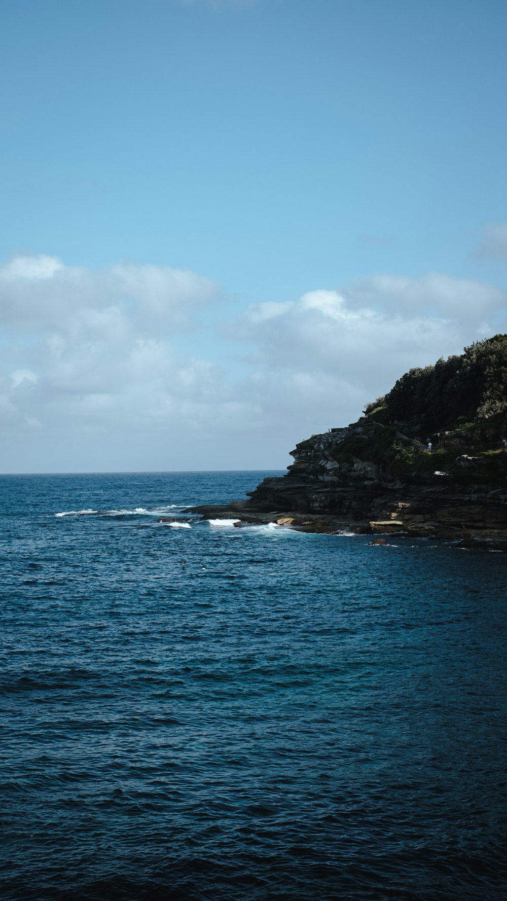 a body of water with a hill in the background