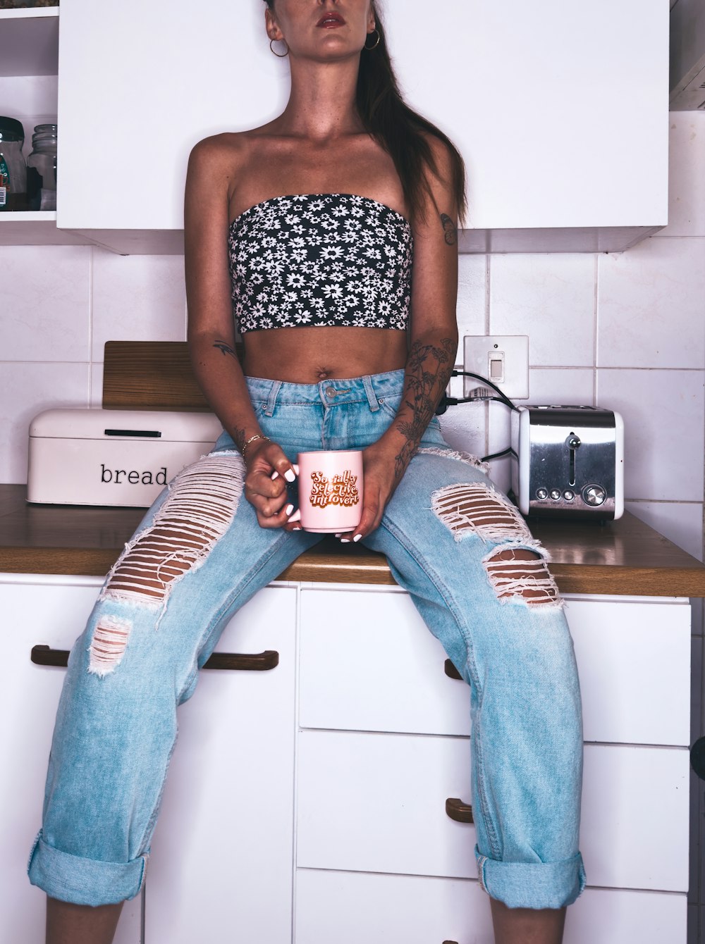 a woman sitting on top of a kitchen counter