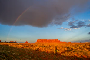 Clouds glowing with deep amber and crimson above a vast desert landscape.
