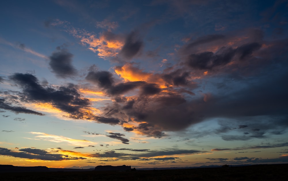 the sun is setting over a field of grass