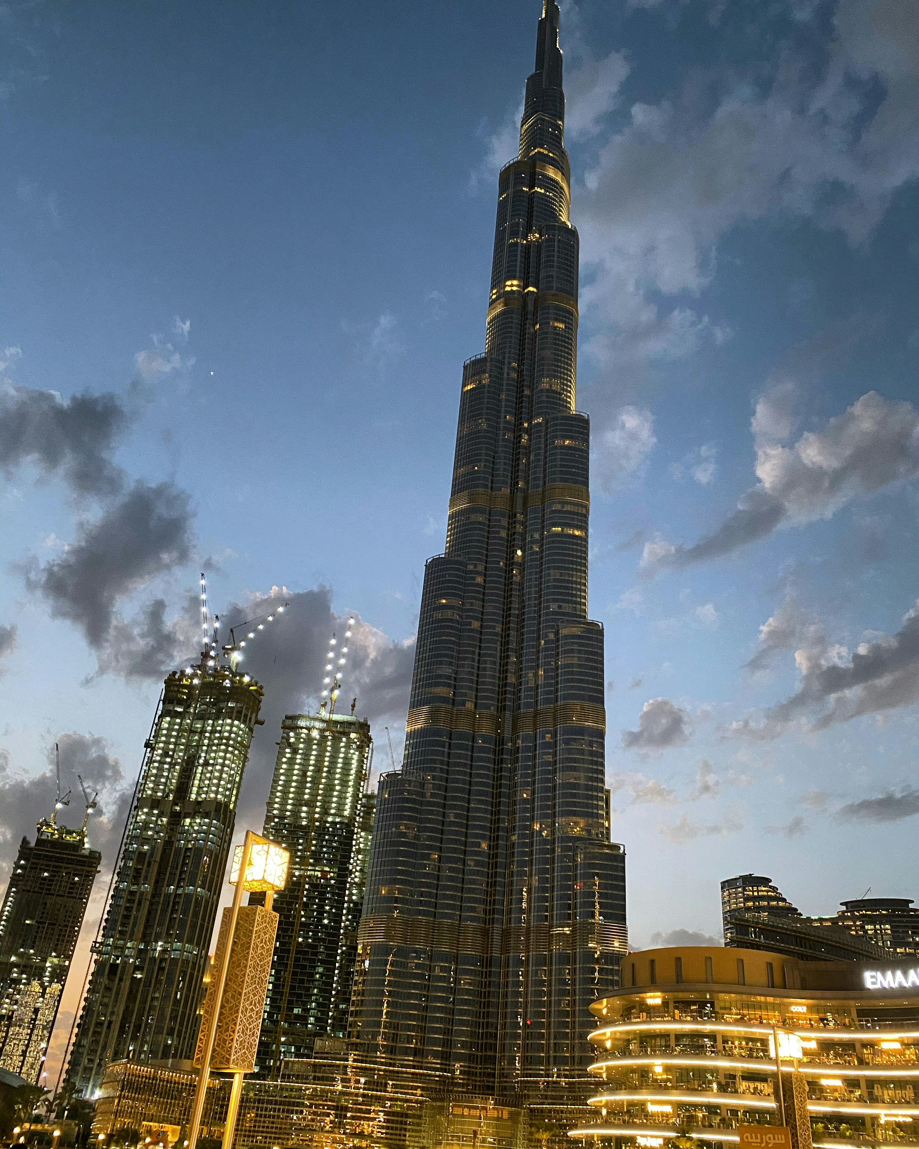 Futuristic Dubai skyline at night with dark desert sky, dramatic deep shadows between glass towers, moody atmospheric city lights