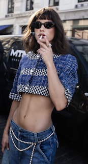 a woman smoking a cigarette on the street