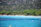 Couple relaxing by turquoise waters surrounded by lush green landscapes