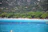 Couple relaxing by turquoise waters surrounded by lush green landscapes