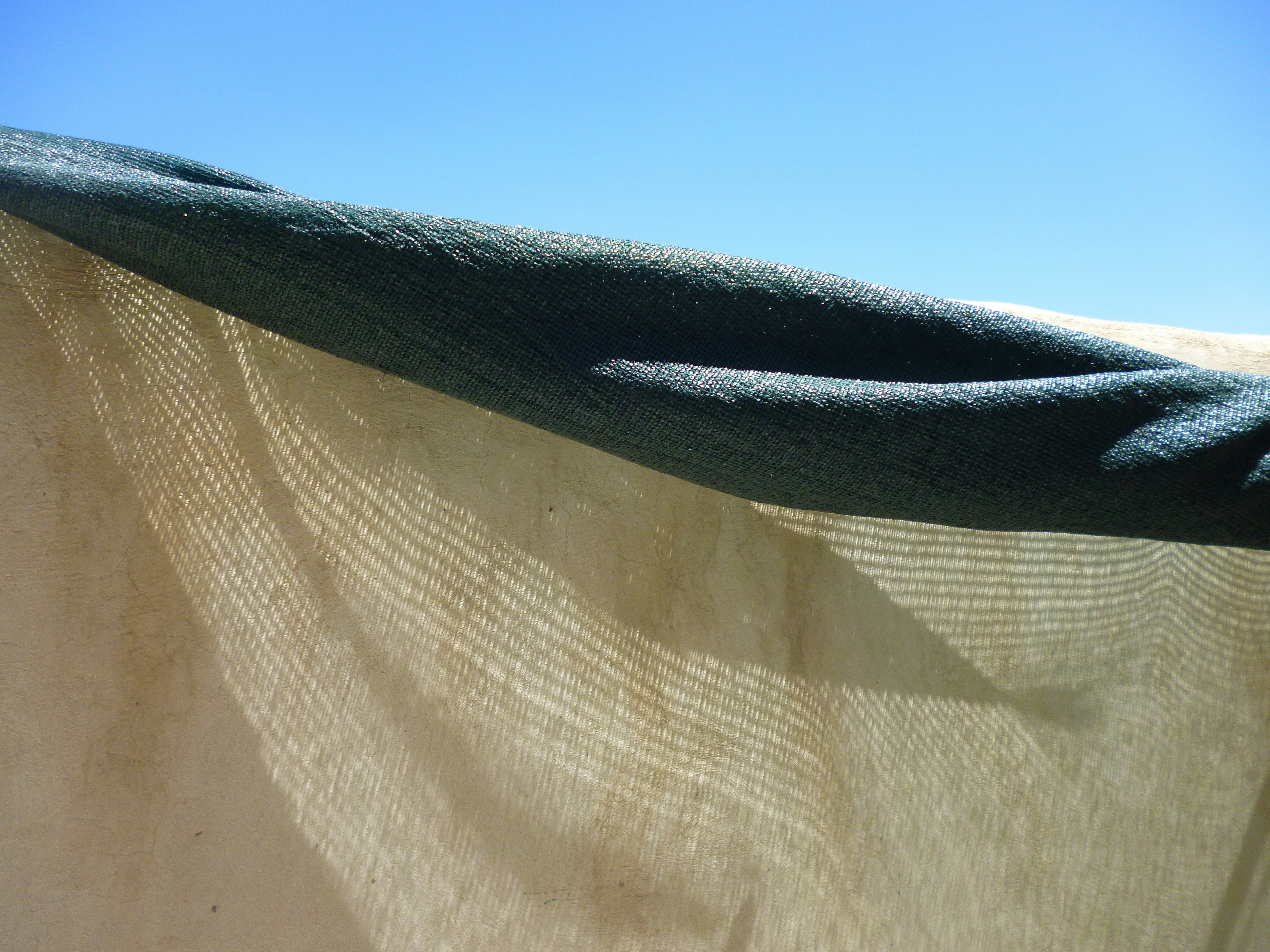 a close up of a curtain with a blue sky in the background