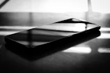 Elegant smartphone resting on a smooth surface with soft shadows.