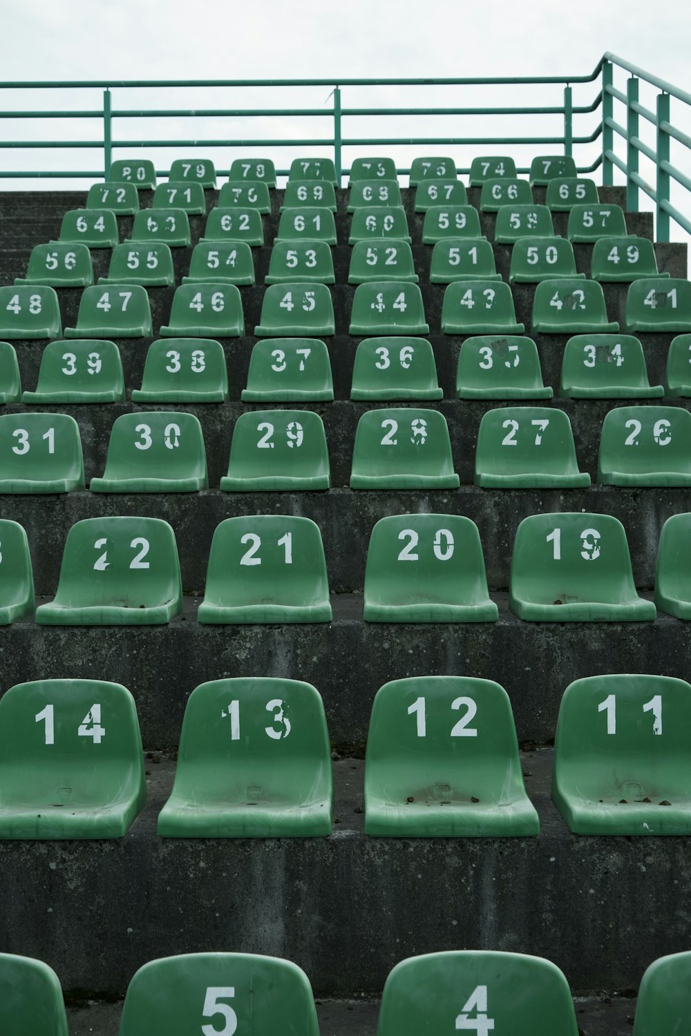 a row of green seats with numbers on them