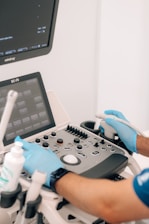 a person in blue gloves is operating a machine