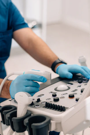 a person in blue gloves operating a machine