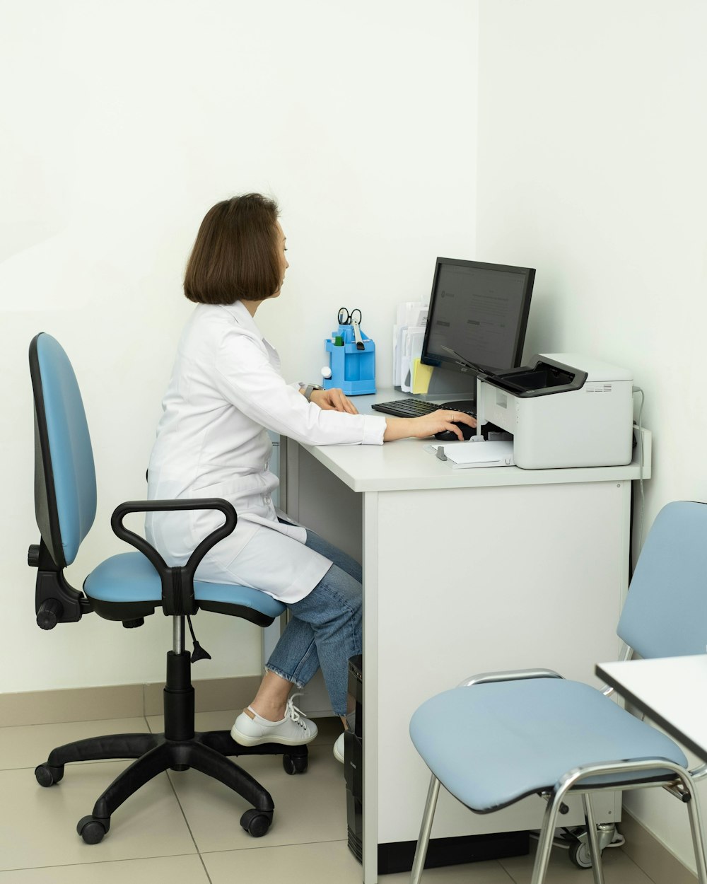 a woman sitting at a desk using a computer