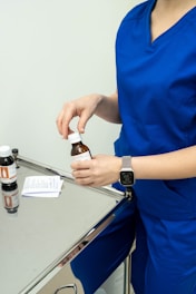 a woman in a blue dress holding a bottle of medicine