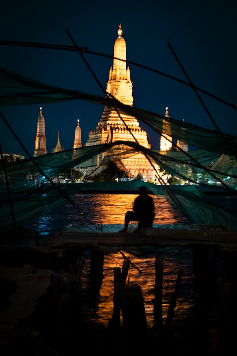 a person sitting on a dock at night