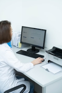 a woman sitting at a desk using a computer