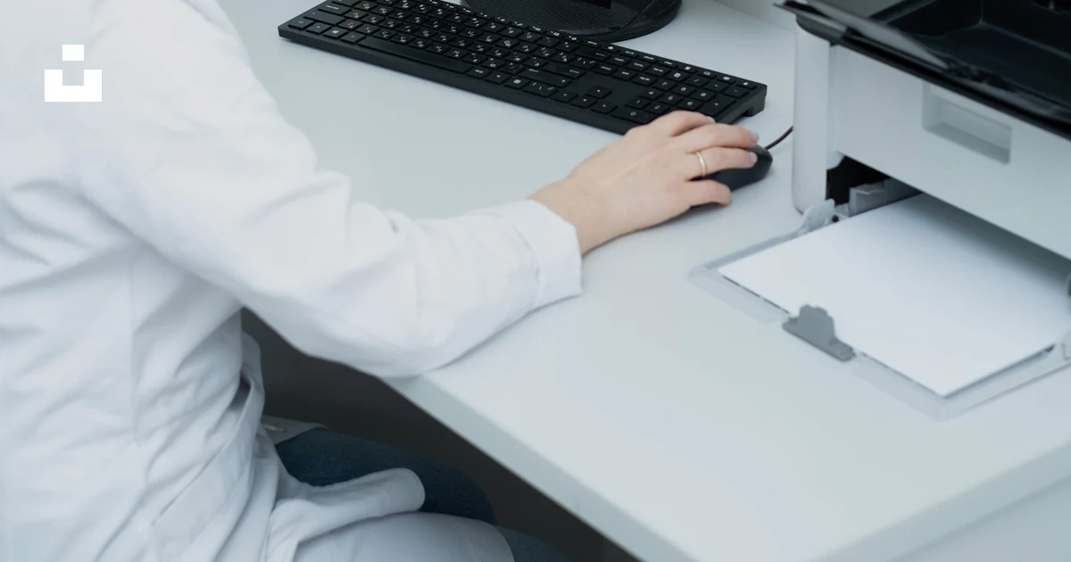 A woman sitting at a desk using a computer photo – Free Computer Image ...