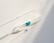 A light-colored medical or scientific instrument with a label stating 'NOT FOR USE IN HUMANS' is positioned horizontally. Thin black wires or threads are also present. The background is plain and neutral, suggesting a clinical or sterile environment.