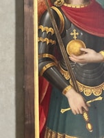 A medieval soldier in ornate armor holds a golden orb and a long staff. The armor is detailed with gold highlights and intricate designs, accompanied by a red cape draped over the shoulders.