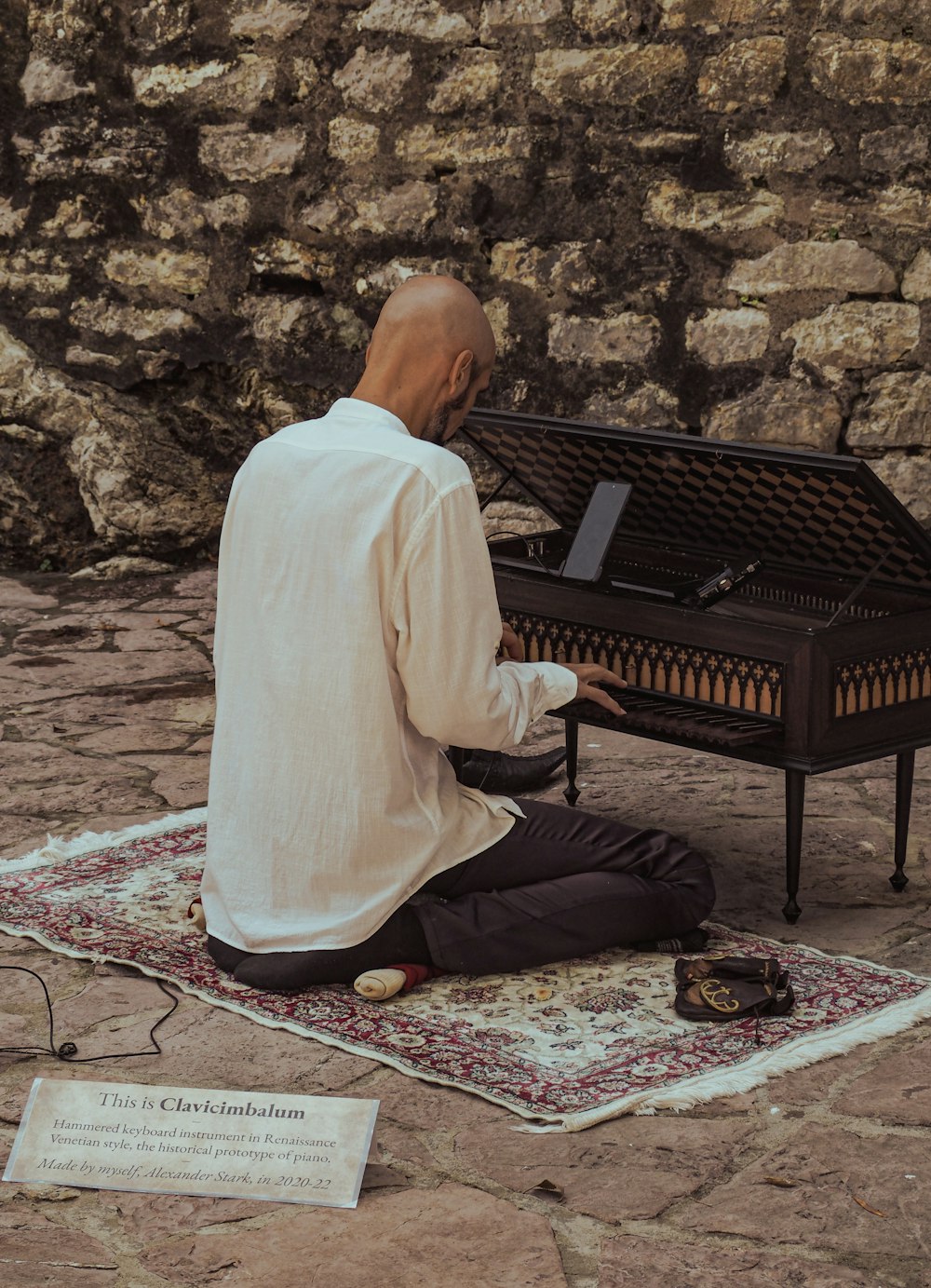 a man sitting on a rug playing a piano