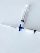 Close-up of surgical gloves and syringes neatly arranged on a sterile surface.