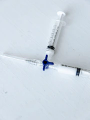 A close-up of pharmaceutical vials and syringes arranged neatly on a clean surface, highlighting injectable products.