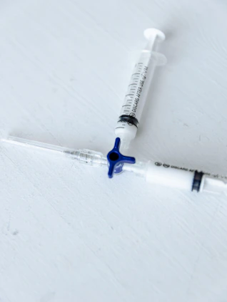 A close-up of pharmaceutical vials and syringes arranged neatly on a clean surface, highlighting injectable products.