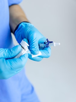 a person in blue gloves holding a syosher