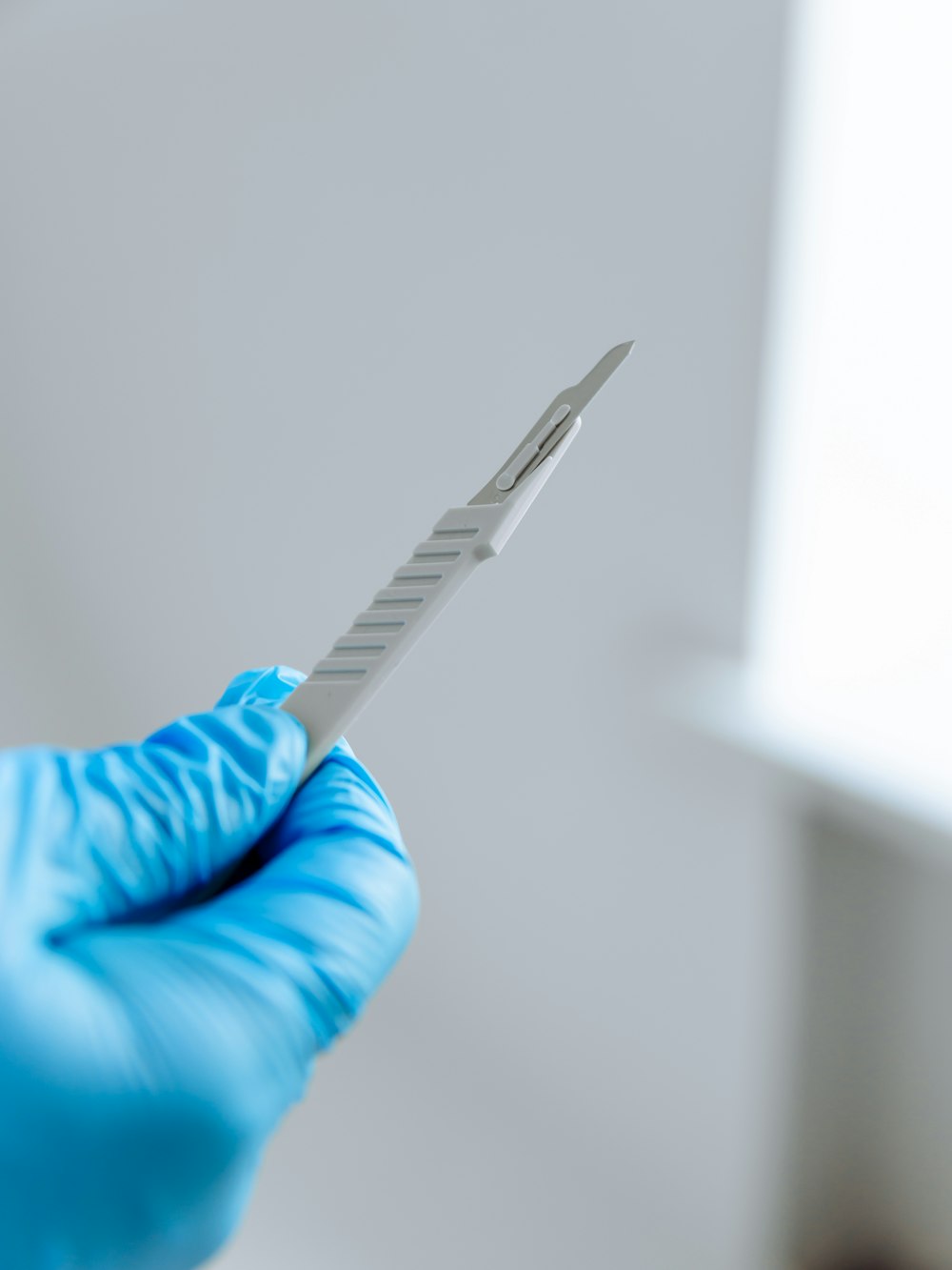 a person in blue gloves holding a toothbrush