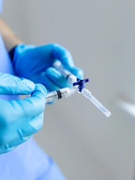 a person in blue gloves holding a syquet