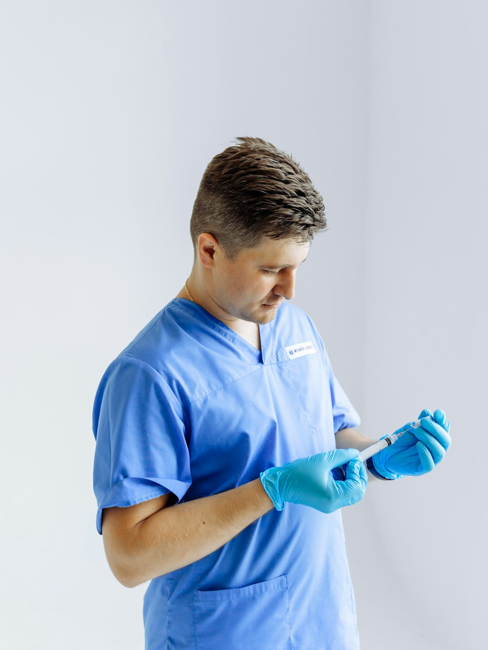 a man in scrubs is looking at his cell phone