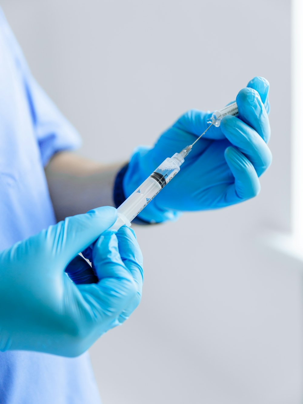 a person in blue gloves holding a toothbrush