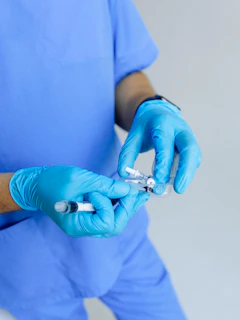 Close-up of a nurse preparing a needle for venous puncture with gloves on