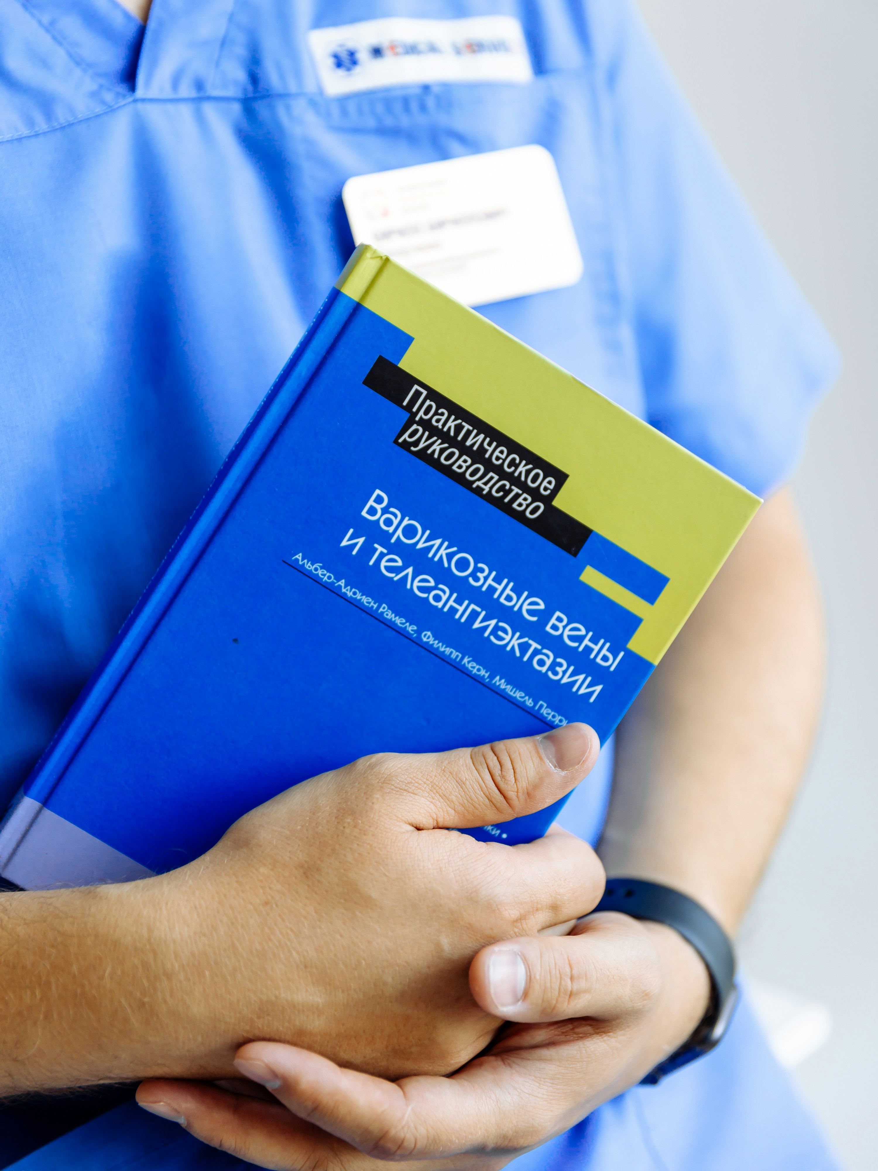 Una persona in scrub con un libro in mano