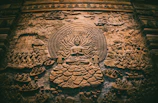 a stone carving of a buddha surrounded by other carvings