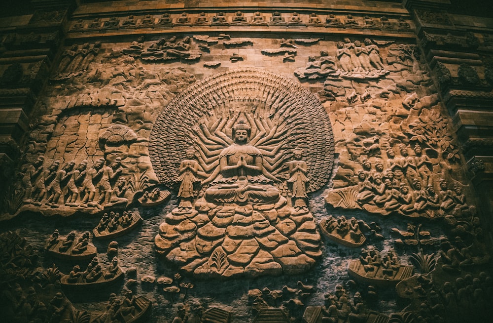 a stone carving of a buddha surrounded by other carvings