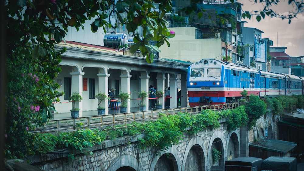a blue and red train traveling over a bridge