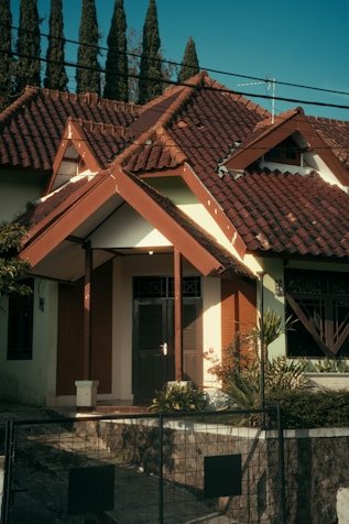 a white and brown house with a red roof