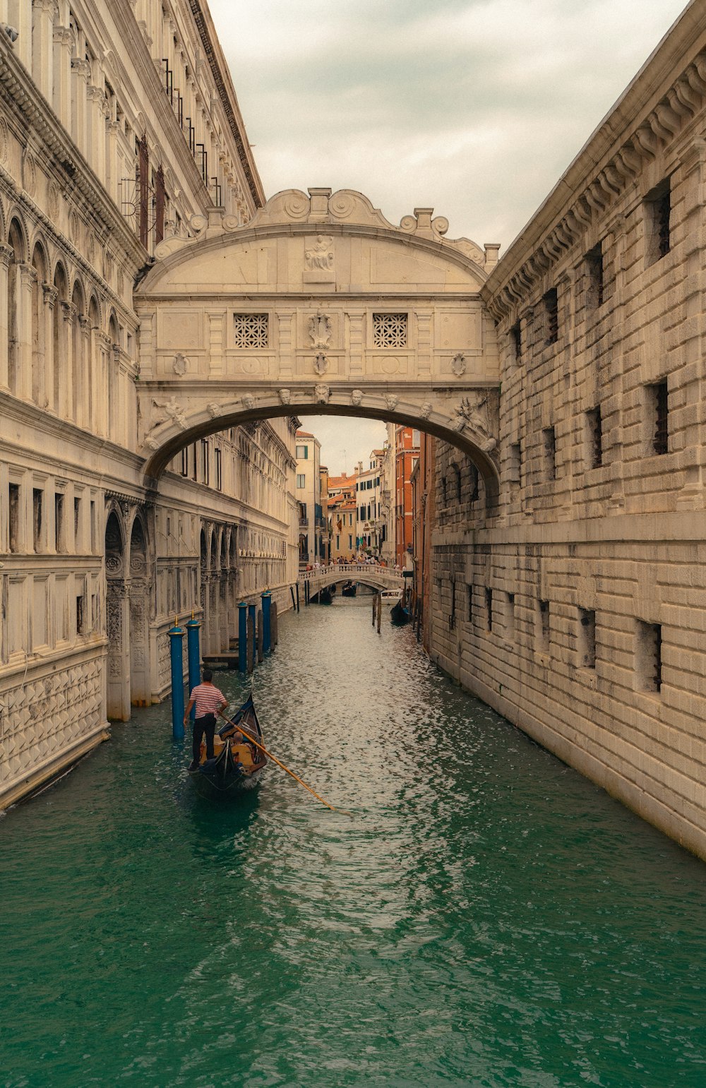 a boat is going under a bridge in a canal